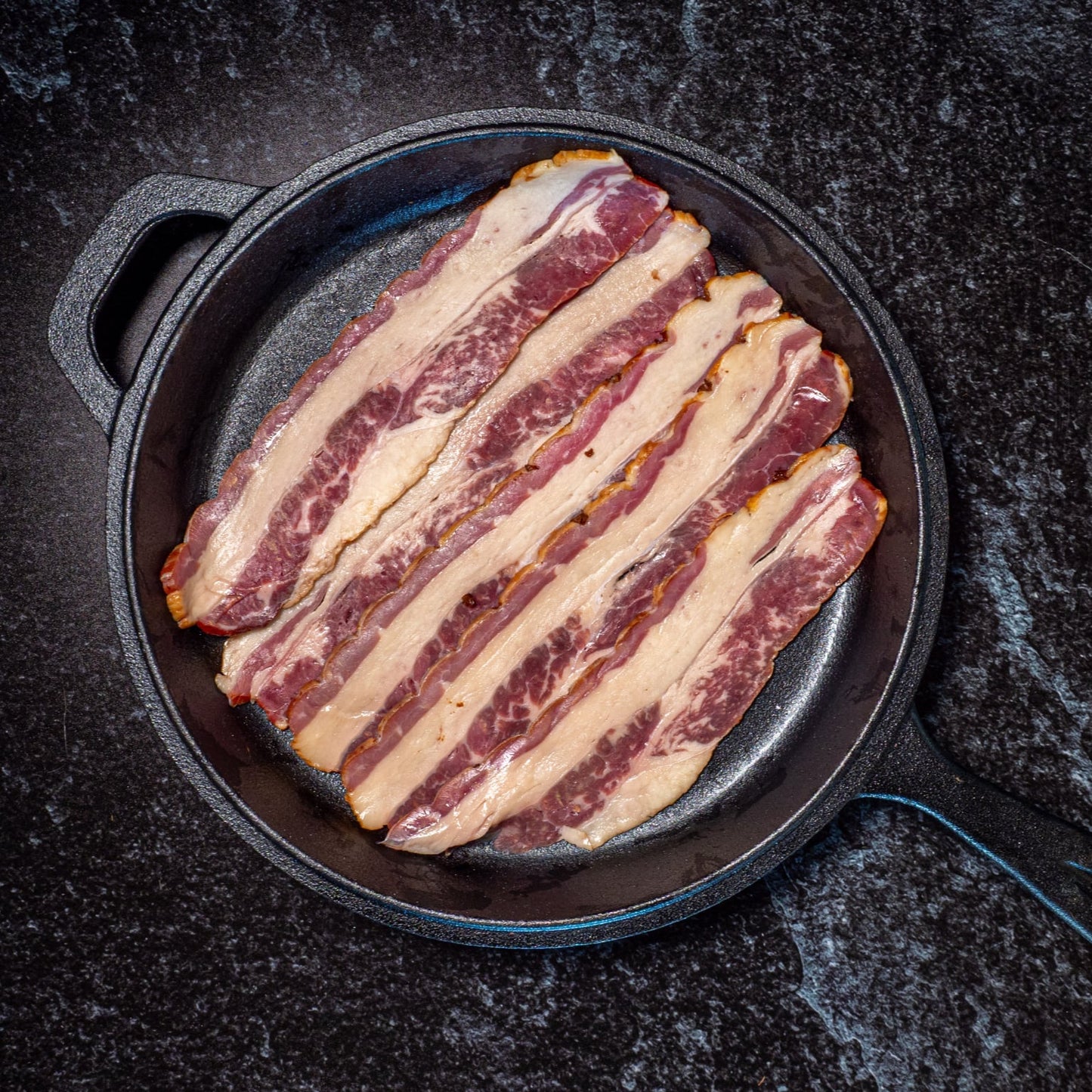 250g pack of NZ beef brisket bacon – grass-fed beef, dry cured and smoked with manuka wood chips cooking cast iron pan